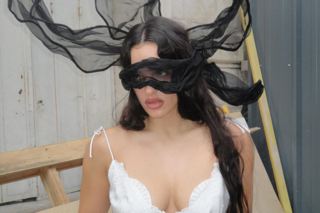 Rosalía con un velo negro en un entorno artístico