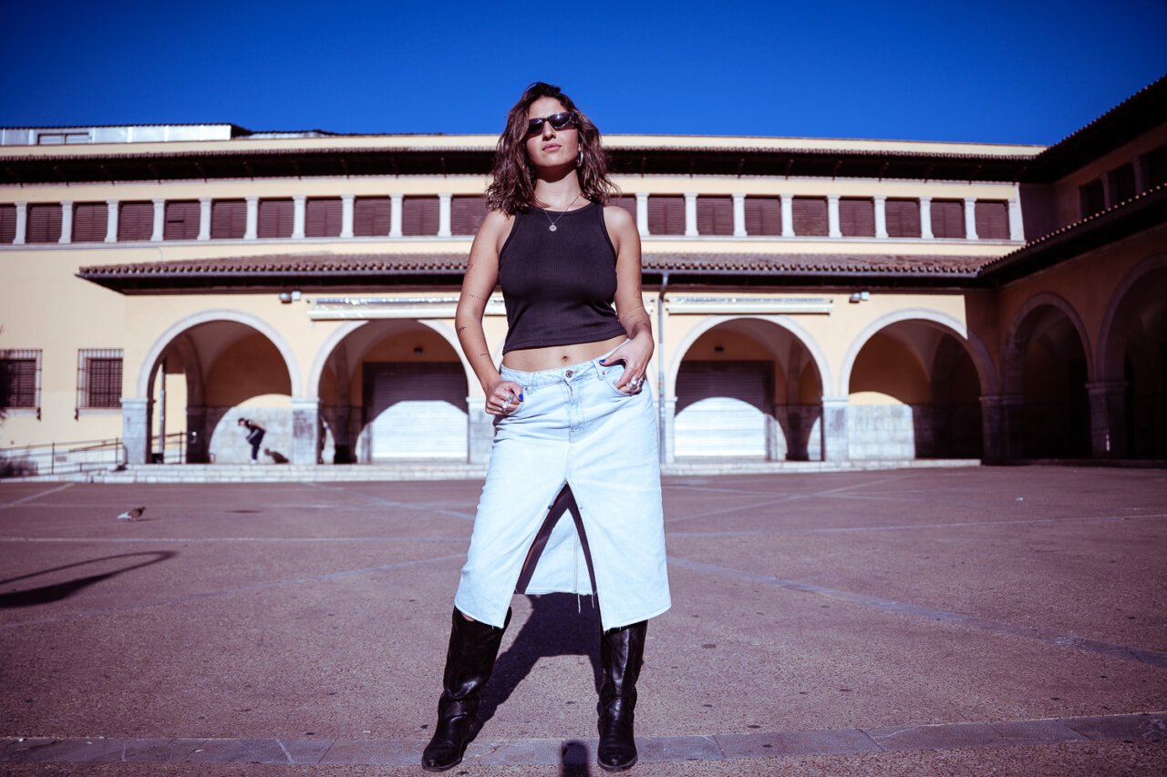 Mujer posando en una plaza con fondo arquitectónico