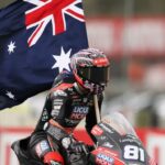 Senna Agius celebrando su victoria en Moto2 con la bandera de Australia