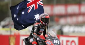 Senna Agius celebrando su victoria en Moto2 con la bandera de Australia