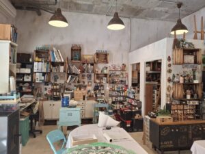 Estudio de arte de Karina Cappato con materiales de pintura y muebles restaurados.