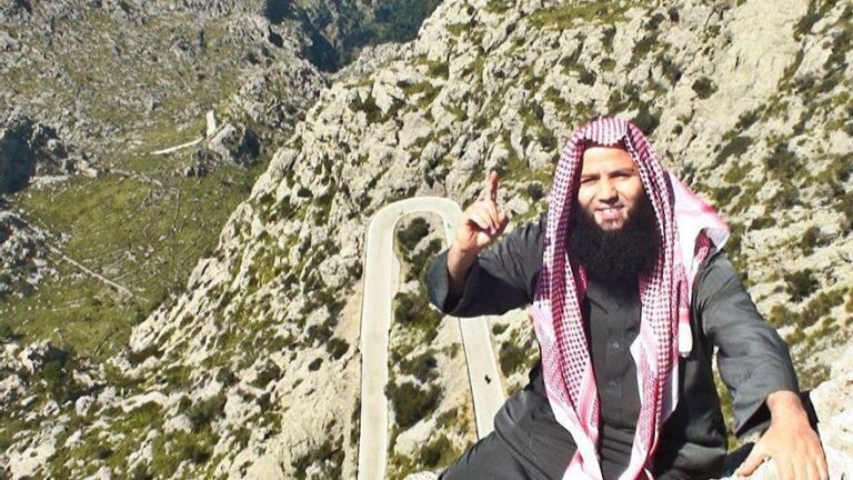 Tarik Chadlioui posando en una montaña con un gesto de señalización.
