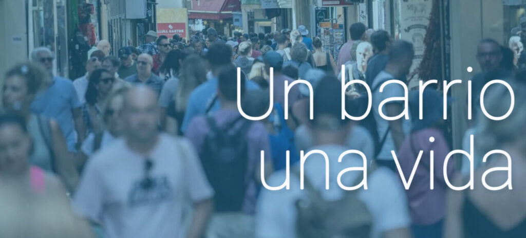 Multitud de personas caminando por un barrio animado