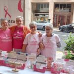 Cuatro mujeres con camisetas de Un Lazo en Movimiento en un evento.