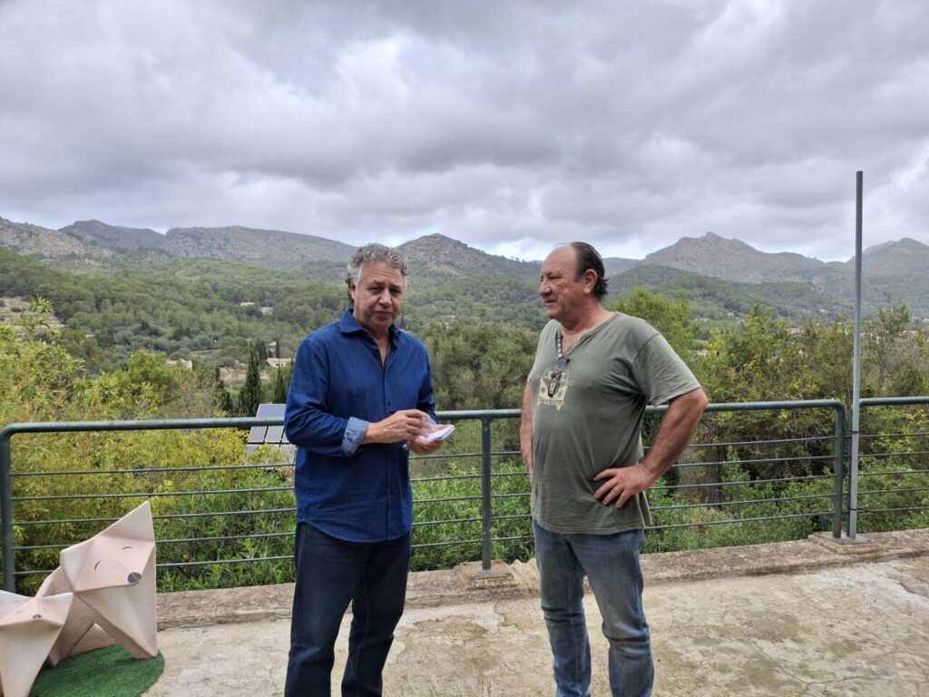 Xisco Barcel&oacute; y Joan Balaguer conversando en una terraza con vistas a monta&ntilde;as.