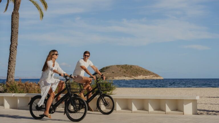 Pareja montando bicicletas en la playa de Magaluf