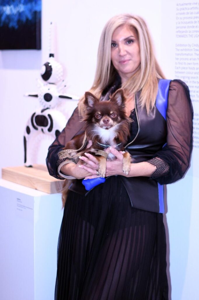 Cindy Amoroso sosteniendo un perro en la inauguración de su exposición.