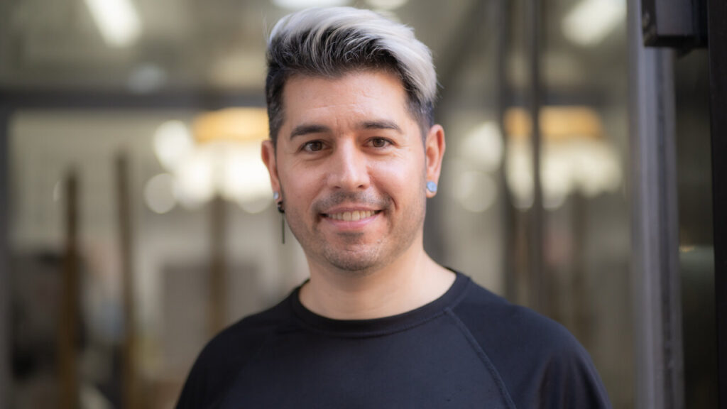 David Carretero, estilista, sonriendo en su salón de belleza.