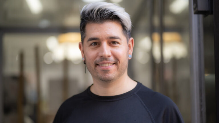 David Carretero, estilista, sonriendo en su salón de belleza.