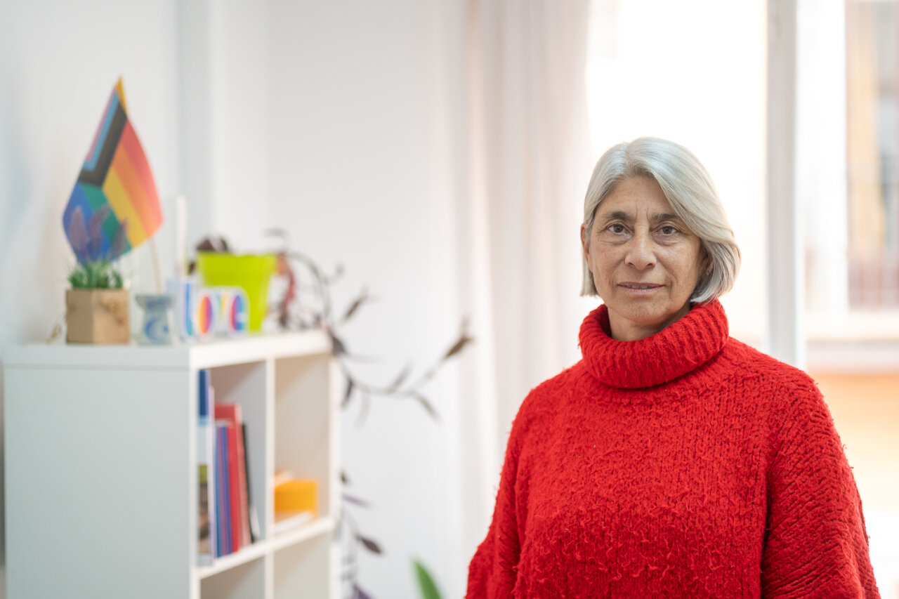 Paz Alcoverro en una entrevista con suéter rojo y fondo claro