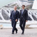 Dos hombres caminando junto a una estructura moderna en Cataluña