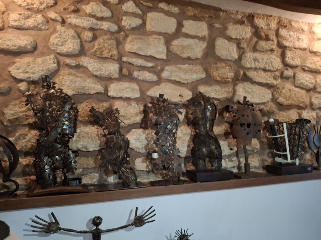 Esculturas de metal del artista Toni Coll en una pared de piedra