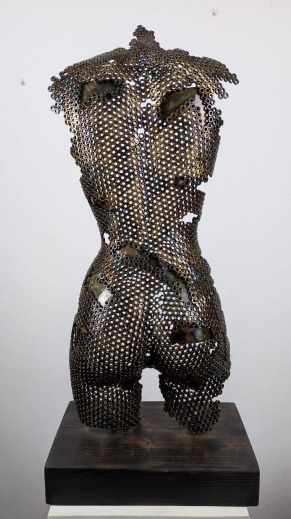 Escultura de torso humano hecha con piezas metálicas