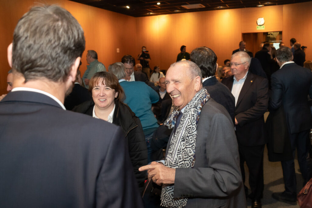 Evento social con personas sonriendo y conversando en un sal&oacute;n.