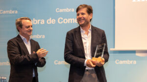 Dos hombres en un evento sosteniendo un premio en la mano.