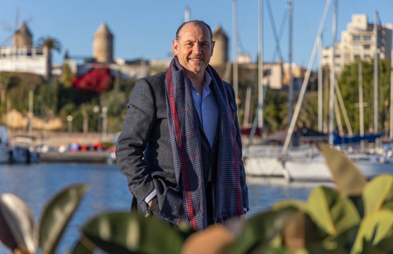 Rafa Gil posando junto al puerto de Palma con un abrigo y bufanda.