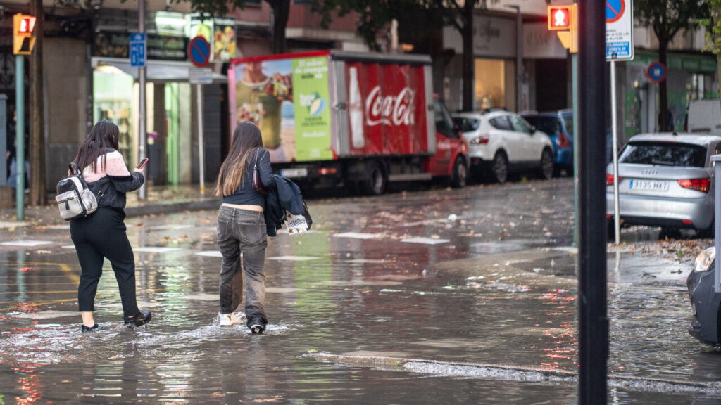 Dos personas caminando por una calle inundada en Palma.