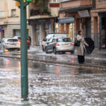 Persona con paraguas en una calle inundada durante una tormenta en Palma