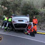 Intervención de bomberos en un accidente de coche volcado en carretera