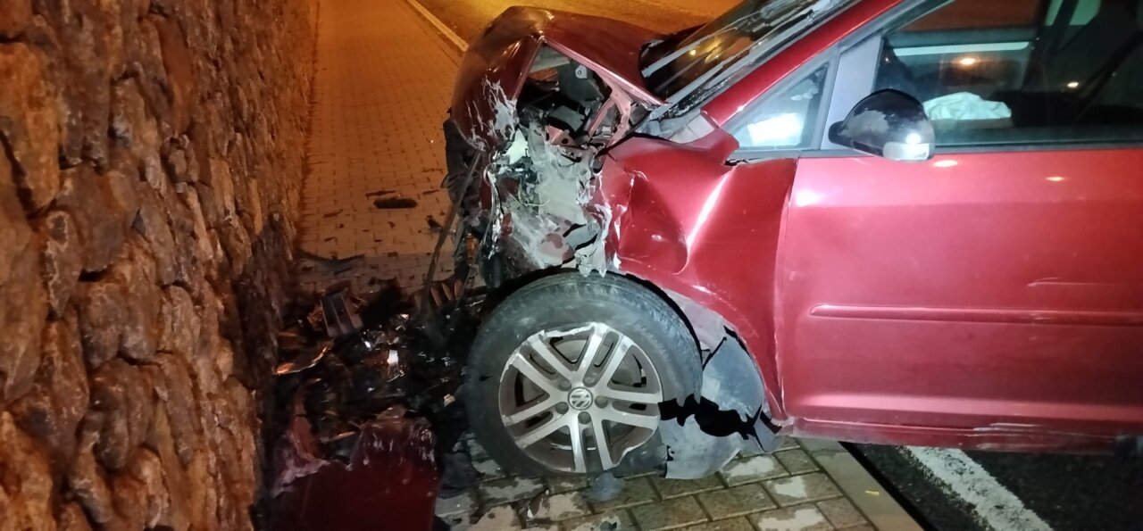 Coche dañado tras accidente en Sóller, Mallorca, con muro de piedra.