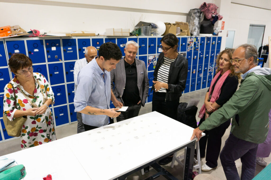 Grupo de personas observando obras de arte en un taller
