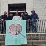 Grupo de personas en un balcón con cartel de Alaró cuina amb bolets