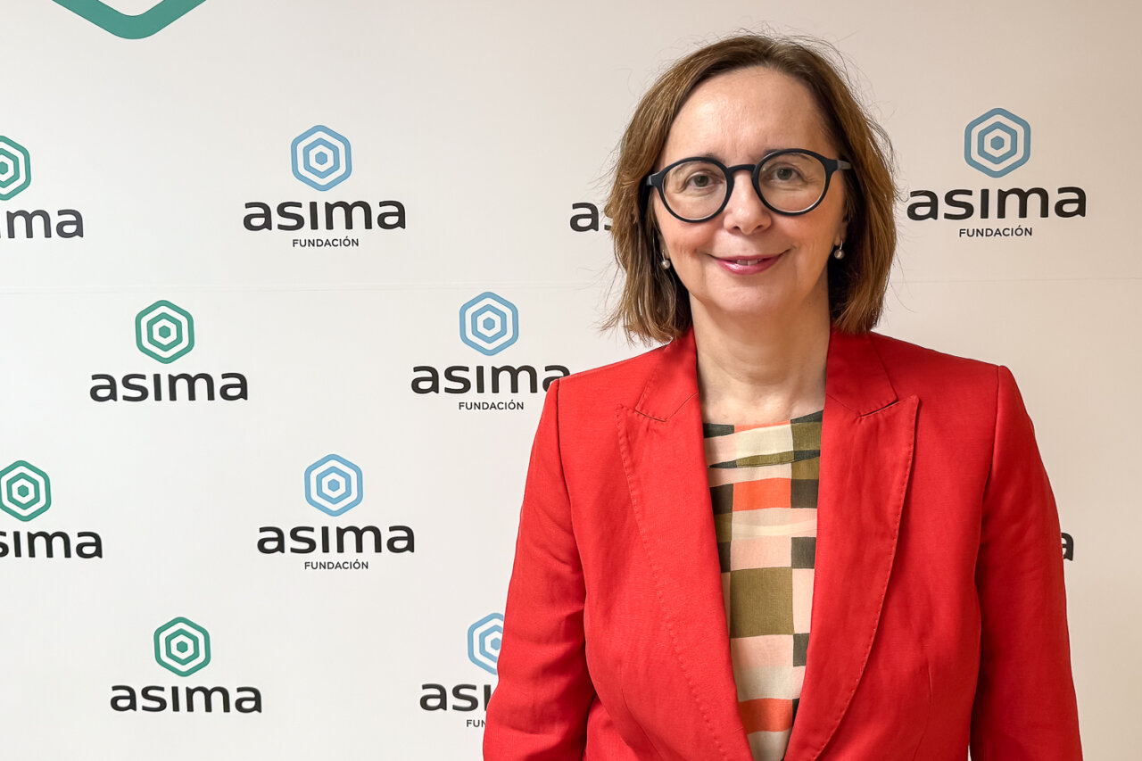 Ana Reguera posando en un evento de Asima con fondo corporativo.