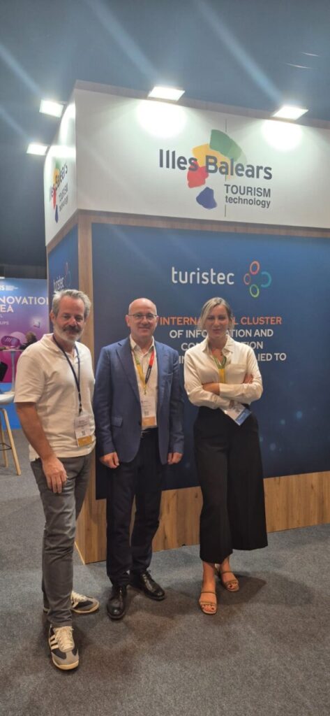 Tres personas en un stand de tecnología turística en Baleares