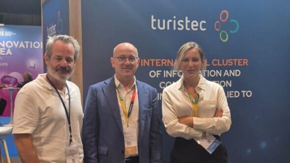 Tres personas en un stand de tecnología turística en Baleares