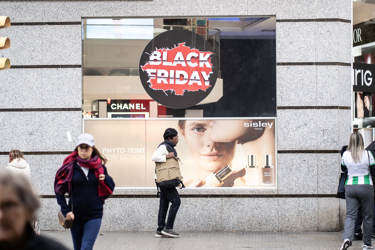 Cartel de Black Friday en una tienda con personas caminando.