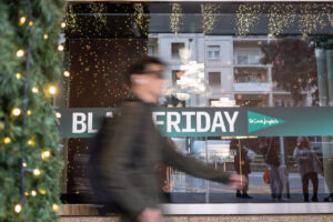 Persona caminando frente a un cartel de Black Friday en El Corte Inglés.