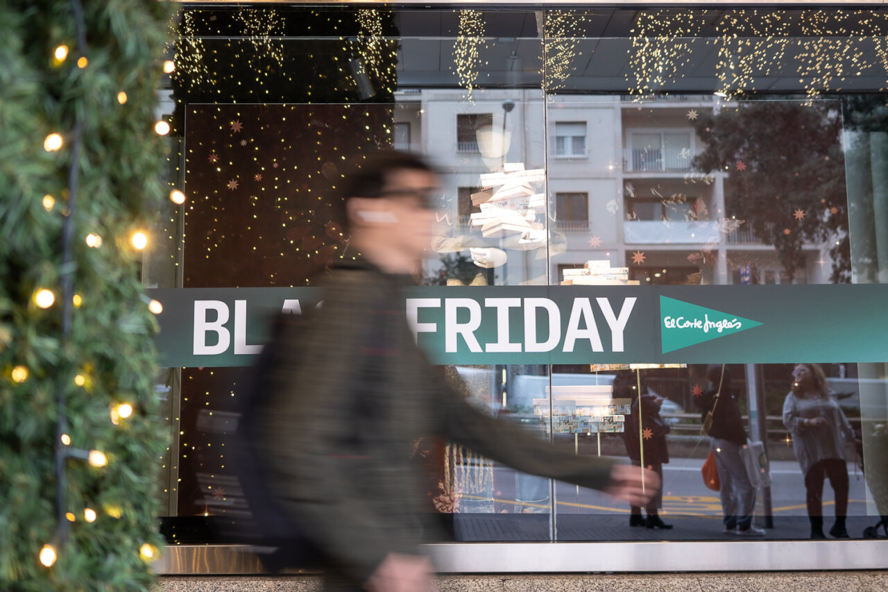 Persona caminando frente a un cartel de Black Friday en El Corte Ingl&eacute;s.
