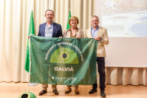 Tres personas sosteniendo una bandera del Movimiento Banderas Verdes 2025 en un evento.