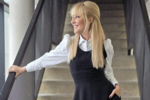 Cayetana Guillén-Cuervo sonriendo en un entorno moderno.