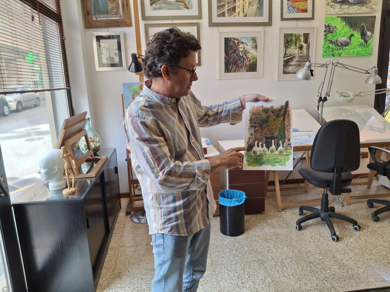 David Santos mostrando una pintura en su estudio de Palma.