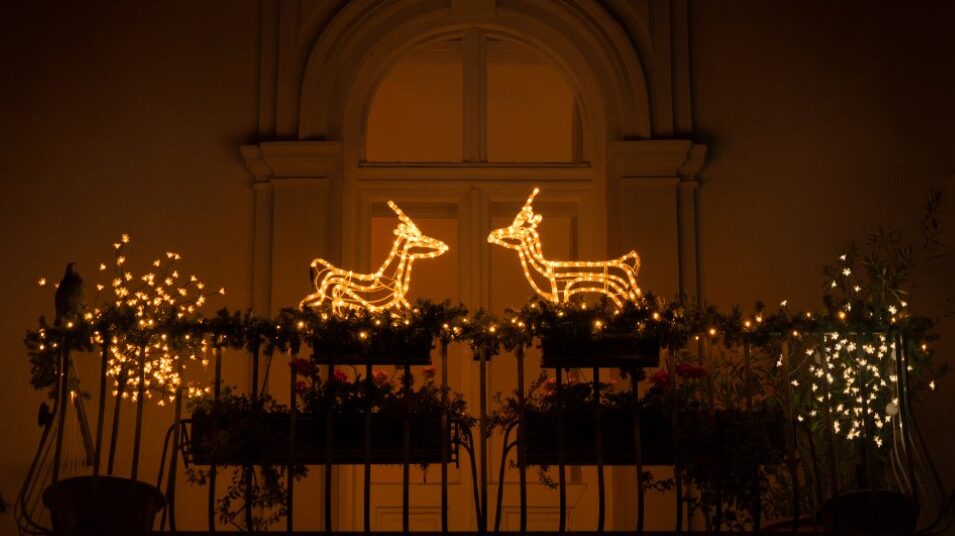 Decoración navideña en un balcón con luces y renos