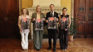 Cuatro personas sosteniendo carteles del concurso de escaparates de Navidad en Mallorca