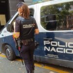 Agente de la Policía Nacional junto a una furgoneta de policía