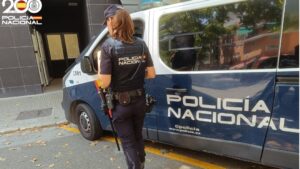 Agente de la Policía Nacional junto a una furgoneta de policía
