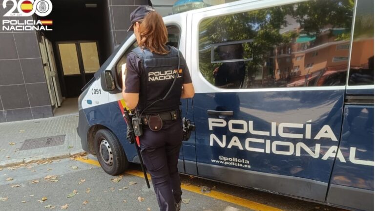 Agente de la Policía Nacional junto a una furgoneta de policía