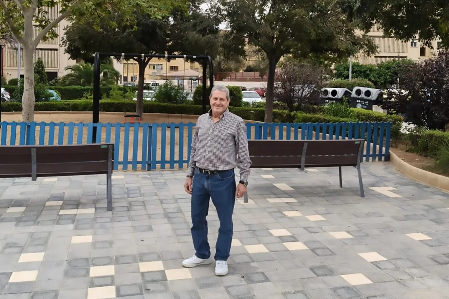 Esteban García en un parque de Sa Garriga, Mallorca, rodeado de bancos y árboles.