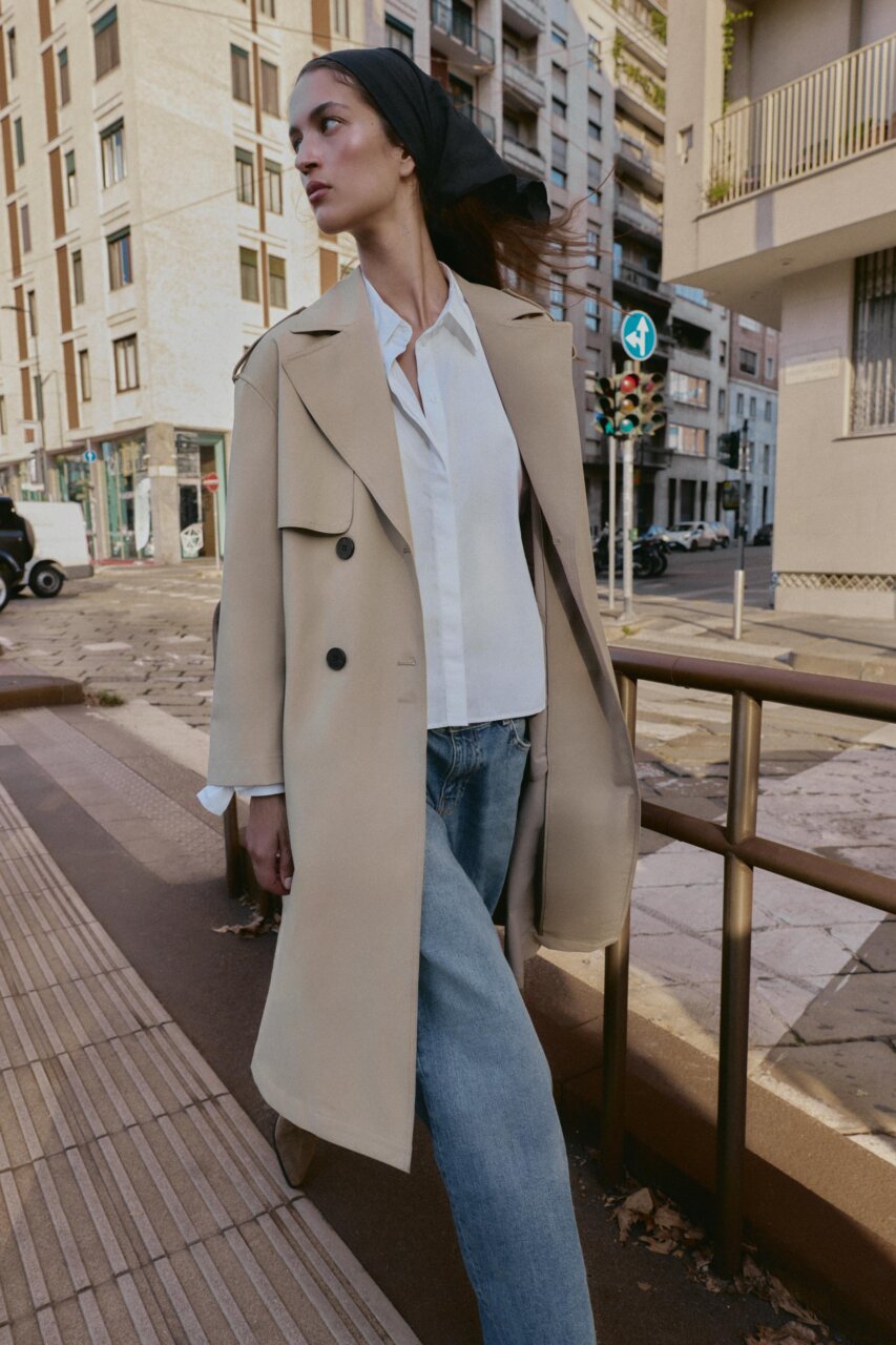 Modelo luciendo una gabardina elegante en la calle.