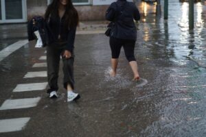 Personas caminando por una calle inundada tras fuertes lluvias en Mallorca.