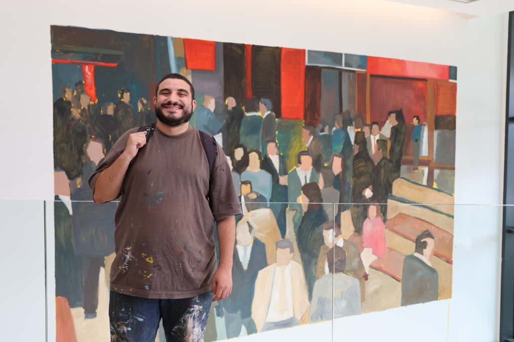 Muralista sonriente frente a su obra en Let’s Art 2025