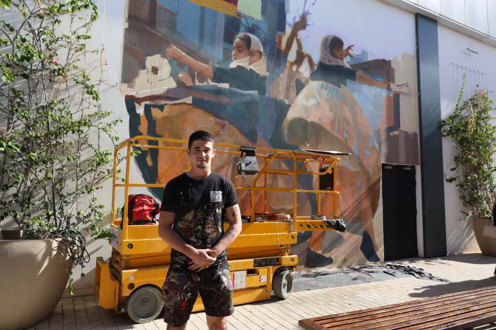Muralista trabajando en una obra en el centro comercial Porto Pi.