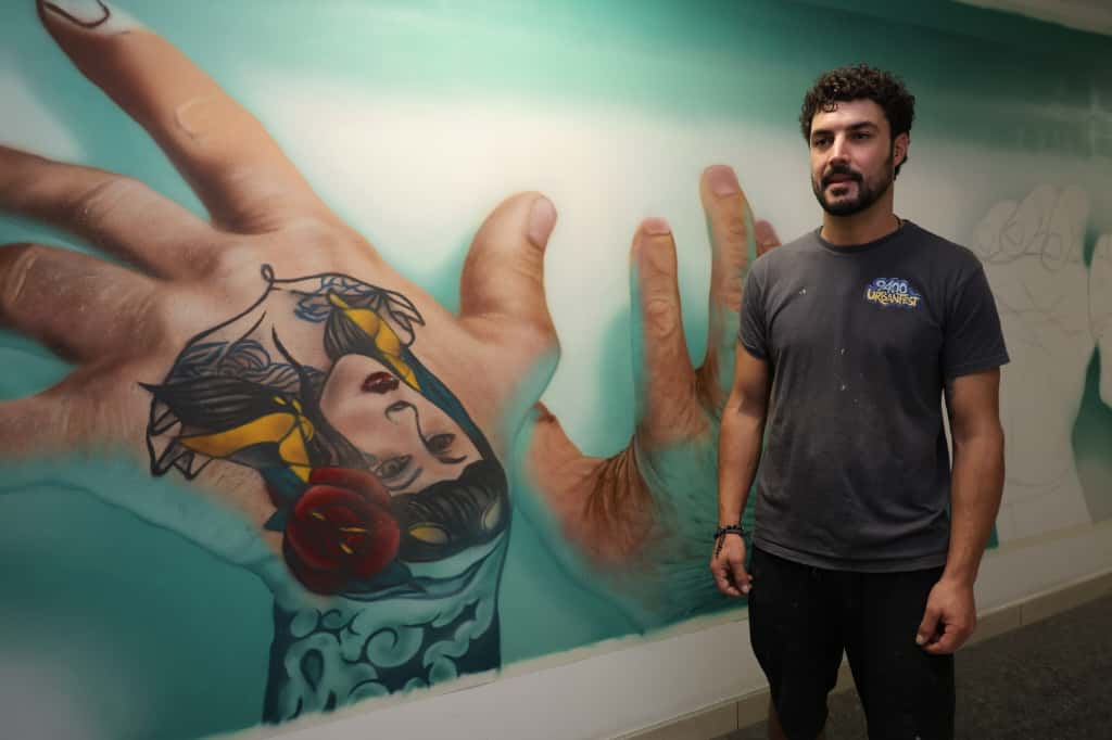 Muralista trabajando en una obra de arte en Porto Pi.