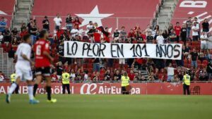 Aficionados del Mallorca sosteniendo una pancarta en el estadio.
