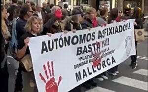 Manifestantes sosteniendo una pancarta en Mallorca pidiendo mejoras para aut&oacute;nomos.