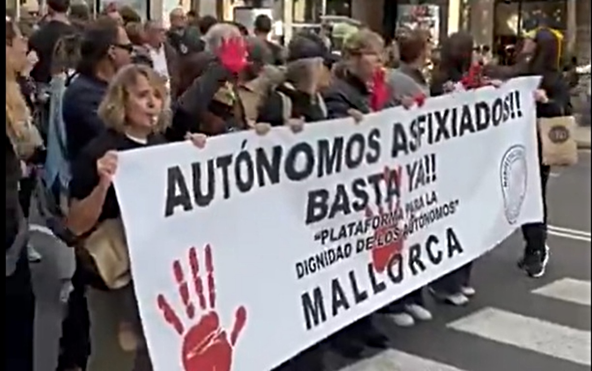 Manifestantes sosteniendo una pancarta en Mallorca pidiendo mejoras para aut&oacute;nomos.