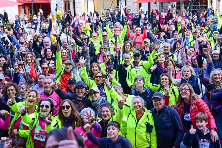 Participantes de la marcha solidaria levantando las manos con entusiasmo.